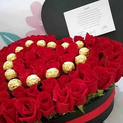 Corazón de rosas rojas con bombones Ferrero Rocher formando un corazón dorado