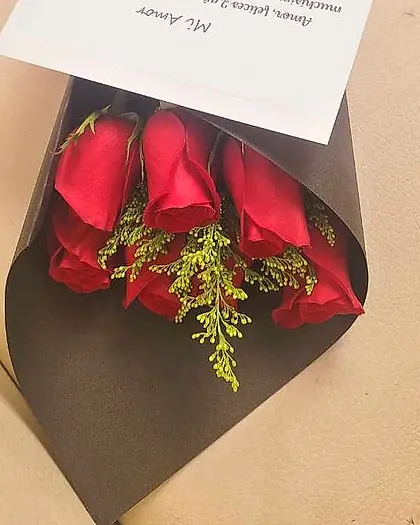Ramo de rosas rojas en papel kraft con barra de chocolate