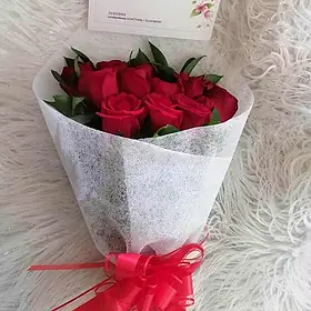 Ramo de rosas rojas en envoltura blanca con moño rojo