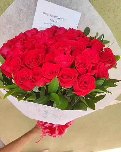 Ramo grande de rosas rojas con follaje verde y tarjeta de cumpleaños