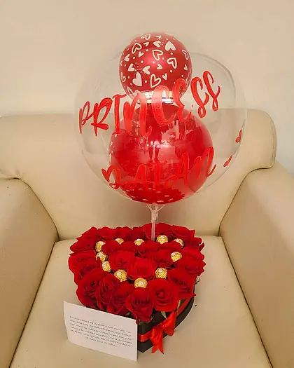 Corazón de rosas rojas con bombones y globo burbuja transparente